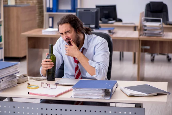 Fiatal férfi alkalmazott alkoholt iszik az irodában — Stock Fotó