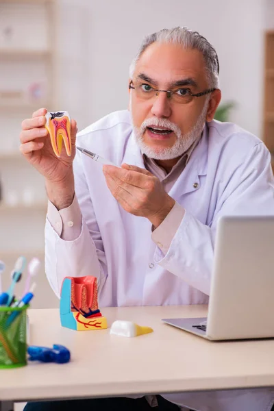 Oude mannelijke tandarts werkt in de kliniek — Stockfoto