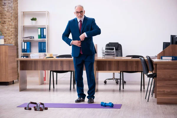Παλιός επιχειρηματίας υπάλληλος που κάνει αθλητικές ασκήσεις στο γραφείο — Φωτογραφία Αρχείου