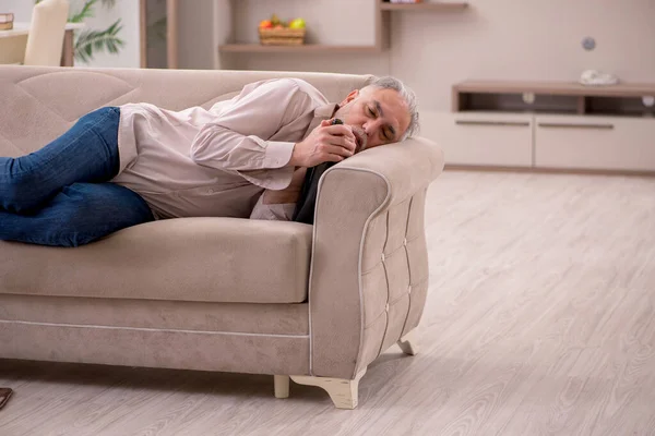 Vieil homme buvant de l'alcool à la maison — Photo