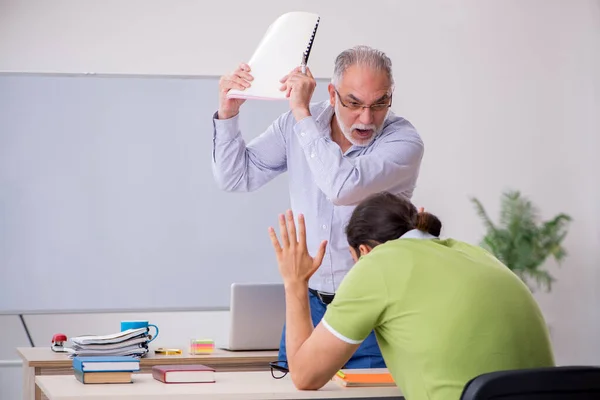 Old male teacher and young male student in the classroom — Stock Photo, Image