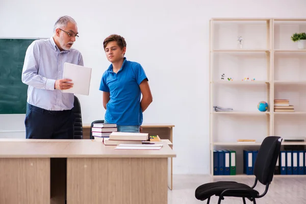 Oude mannelijke leraar en schooljongen in de klas — Stockfoto