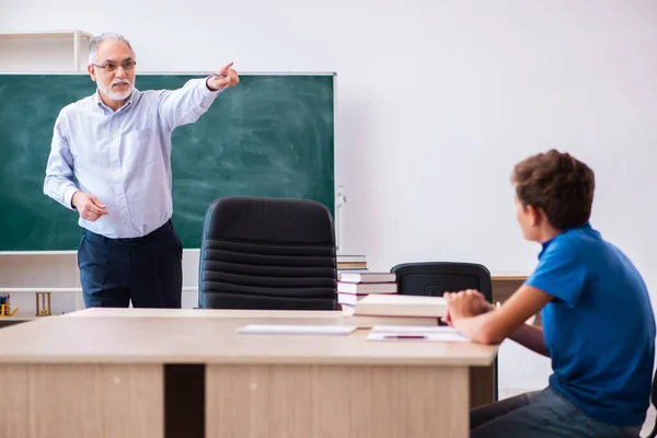 Viejo maestro y colegial en el aula — Foto de Stock