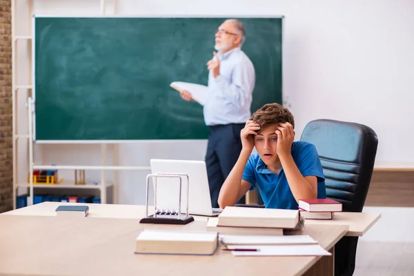 Gammal manlig lärare och skolpojke i klassrummet — Stockfoto