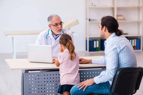 Babasıyla küçük bir kız yaşlı erkek doktoru ziyaret ediyor. — Stok fotoğraf