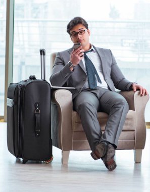 Havaalanındaki iş yerinde genç işadamı uçuş için bekliyor.