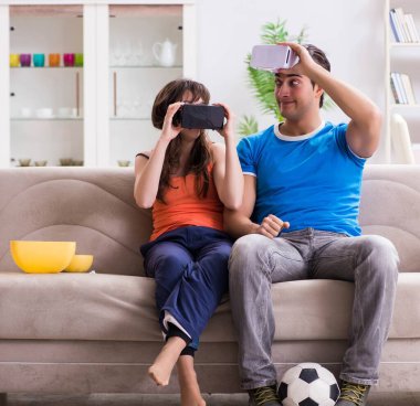 Adam sanal gerçeklik VR gözlükleriyle futbol izliyor.