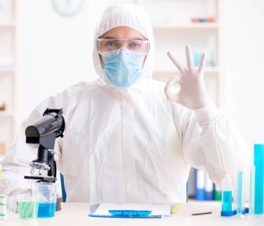 Laboratuvarda kimyasallar üzerinde çalışan genç bir kimyager.