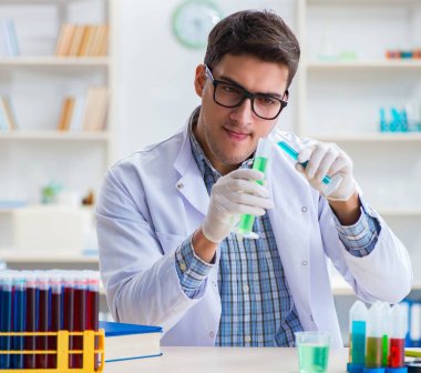 Laboratuvarda kimyasallar üzerinde çalışan genç bir kimyager.