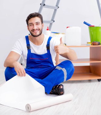 VR gözlüklü, duvar kağıdı yapıştıran bir adam.