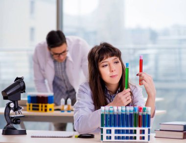 Laboratuvarda deney yapan iki kimyager.