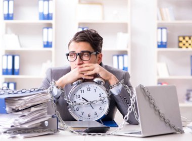 Ofis masasına zincirlenmiş meşgul bir çalışan.