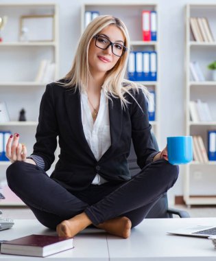 İş kadını ofiste meditasyon yaparken hayal kırıklığına uğradı