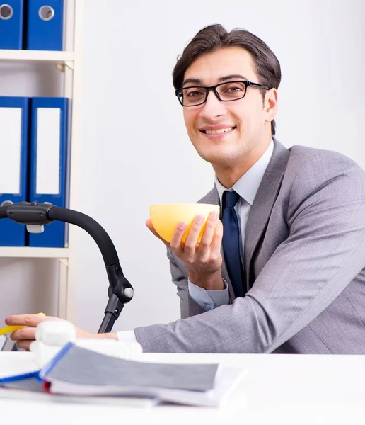 Businessman looking after newborn baby in office