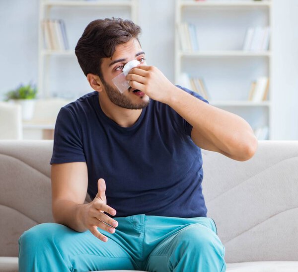 Young man recovering healing at home after plastic surgery nose