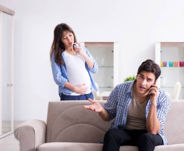 Evde kocası olan hamile bir kadın.