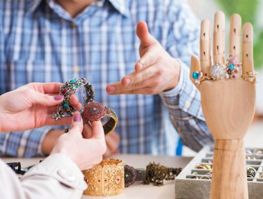 Mücevher değerlendirmesi için kuyumcuyu ziyaret eden kadın.