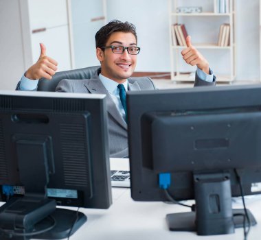 Birçok ekranın önünde oturan bir iş adamı