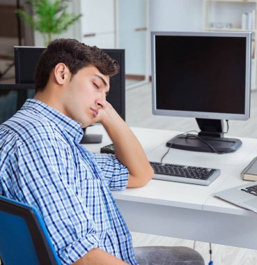 Birçok ekranın önünde oturan bir iş adamı