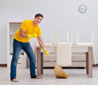 Koca adam evi temizliyor, karısına yardım ediyor.