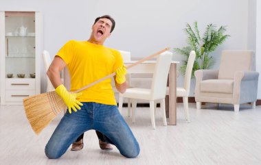 Süpürgeyle sanal gitar çalan komik adam.