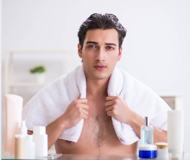 Genç adam banyoda çalışmak için hazırlanıyor.