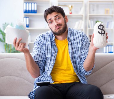 Ödeme yapması gereken faturalara kızgın bir adam.