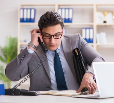 İşadamı ofis telefonundan konuşuyor.