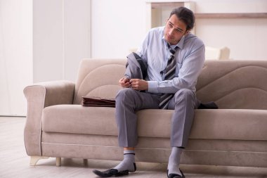 Yorgun genç işadamı işten sonra eve geliyor.