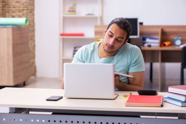 Tele-eğitimde sınavlara hazırlanan genç bir erkek öğrenci