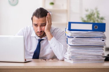 Genç işadamı ofisteki aşırı işten memnun değil.