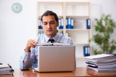 İş yerinde kitap okuyan genç bir erkek öğrenci.