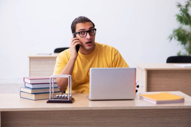 Sınav hazırlıkları sırasında cep telefonu tutan genç bir öğrenci.