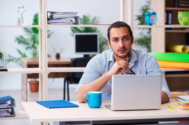 Ofiste çalışan genç bir erkek.