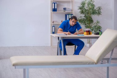 Genç erkek doktor hastanede not alıyor.