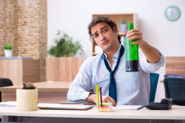 İş yerinde alkol alan genç bir erkek işçi.