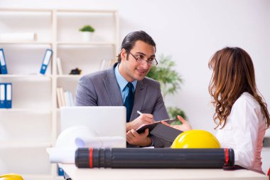 Genç işadamı ve bayan mimar yeni projeyi tartışıyor