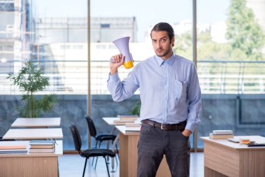 Sınıftaki genç erkek öğretmen.