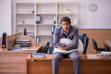 İş yerinde uyuyan genç bir erkek işçi.