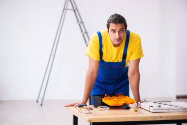 Genç erkek marangoz içeride çalışıyor.