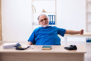 Yaşlı erkek doktor gece vardiyasından sonra çok yorgun.