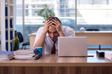 Ofiste çalışan alkol bağımlısı genç bir erkek.