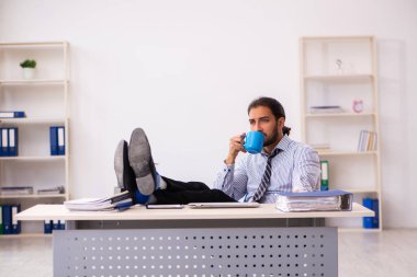 Molada kahve içen genç bir erkek.