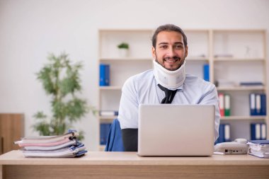 Ofiste çalışırken kaza geçirmiş genç bir adam.