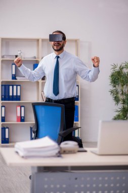 İş yerinde sanal gözlük takan genç bir erkek çalışan.