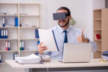 İş yerinde sanal gözlük takan genç bir erkek çalışan.