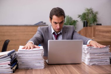 Ofisteki aşırı işten memnun olmayan genç bir erkek işçi.