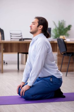 Mola sırasında spor yapan genç erkek çalışanlar.