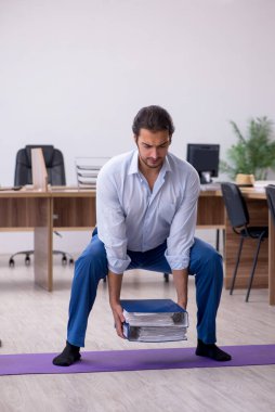 Mola sırasında spor yapan genç erkek çalışanlar.