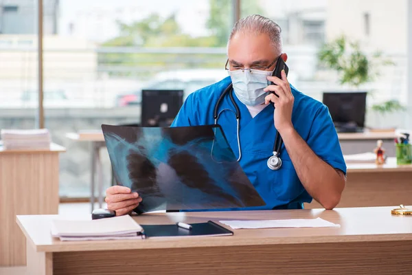 Old male doctor radiologist working in the clinic